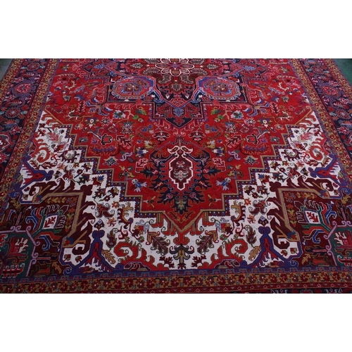 1489 - A large rectangular woollen carpet, colourfully worked in the typical Middle Eastern manner with hoo... 