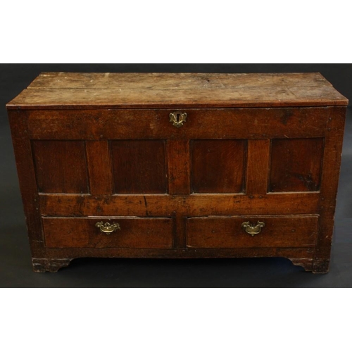 1496 - An 18th century oak mule chest, plank top above a four panel front, the base with a pair of drawers,... 