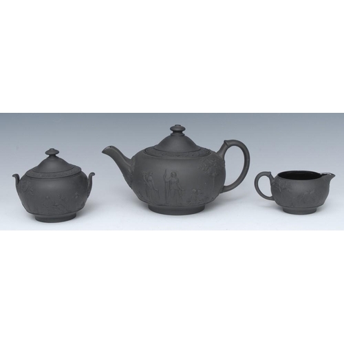 356 - A Wedgwood three piece black basalt teapot, milk jug and sugar bowl, in relief with classical figure... 