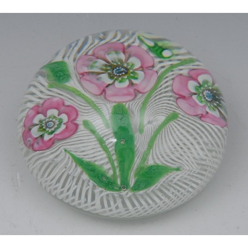 385 - A St Louis type bouquet paperweight, with three pink flower and green leaves, set on a bed of spiral... 