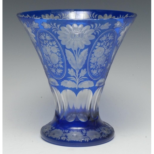 386 - A 19th century Bohemian blue flash glass trumpet-shaped vase, cut and etched with a profusion of cou... 