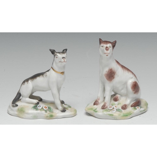 394 - A pair of German porcelain models, of seated dogs, each naturalistically modelled on a grassy mound ... 