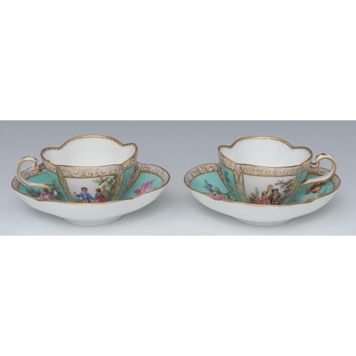 396 - A pair of German quatrefoil cabinet cups and saucers, decorated with alternating panels of courting ... 