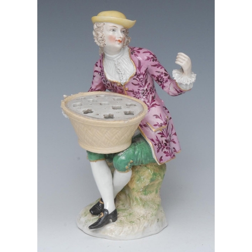 397 - A Continental figure, of a flower seller, seated wearing a broad brimmed yellow hat, pink jacket wit... 