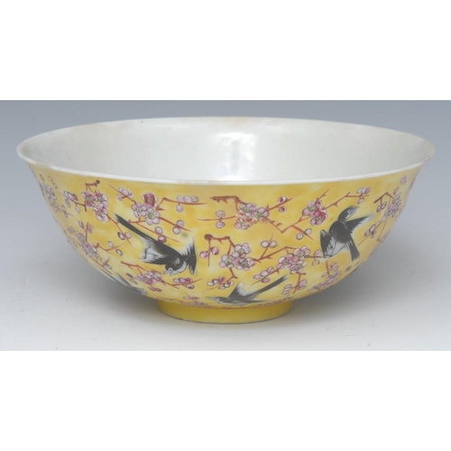 421 - A 19th century Chinese bowl, decorated with song birds on blossoming prunus branches on a yellow gro... 