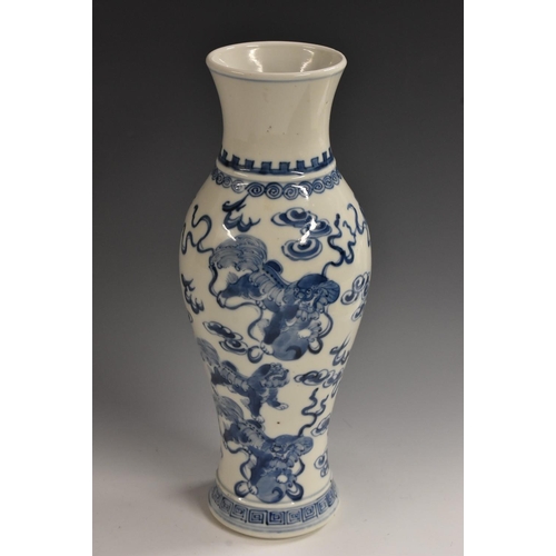 443 - A Chinese slender ovoid vase, painted in tones of underglaze blue with temple lions amongst scrollin... 