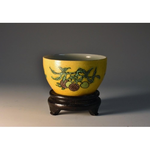 446 - A Chinese wine cup, painted in tones of green, black and manganese with peaches and rip fruit, on a ... 