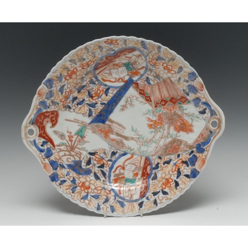 457 - A Japanese shaped circular two-handled serving dish, painted in the Imari palette and picked out in ... 