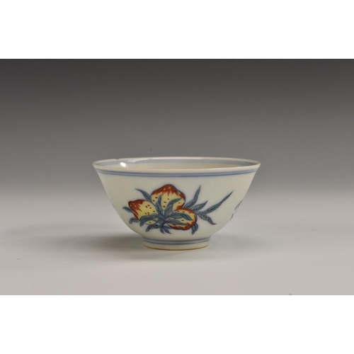 471 - An 18th century Chinese tea bowl, the exterior with fruit sprigs, in blue, picked out in orange and ... 