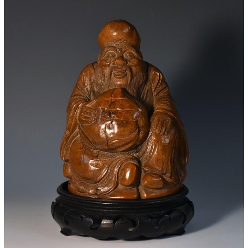 478 - A Chinese bamboo figure, carved as a bearded immortal holding a peach, 15.5cm high, hardwood stand