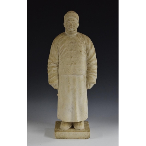 481 - A Chinese marble figure, carved as a man in a traditional tunic and fur hat, rectangular base, 57.5c... 