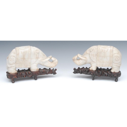 484 - A pair of 19th century Chinese carved marble models of stylised elephants, with trunks raised, drape... 