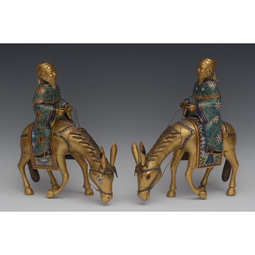 485 - A pair of 19th century Chinese cloisonné models of scholars riding donkeys, each gilt and brightly d... 