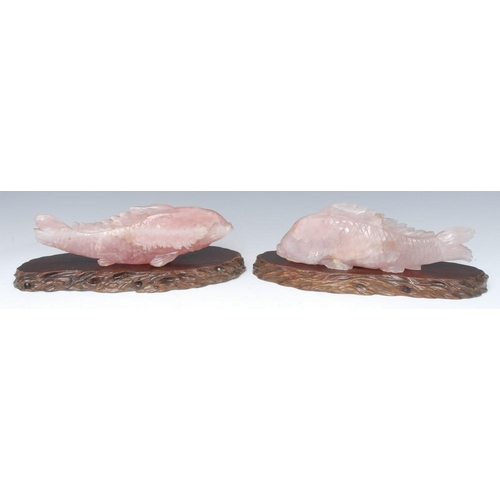 486 - A pair of Chinese rose quartz fish, incised with scales, 26cm wide, hardwood stands  Provenance: Fro... 