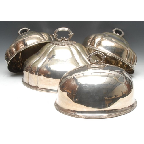 513 - A graduated set of three Victorian EPNS fluted oval meat domes, lotus loop handles, the largest 46.5... 