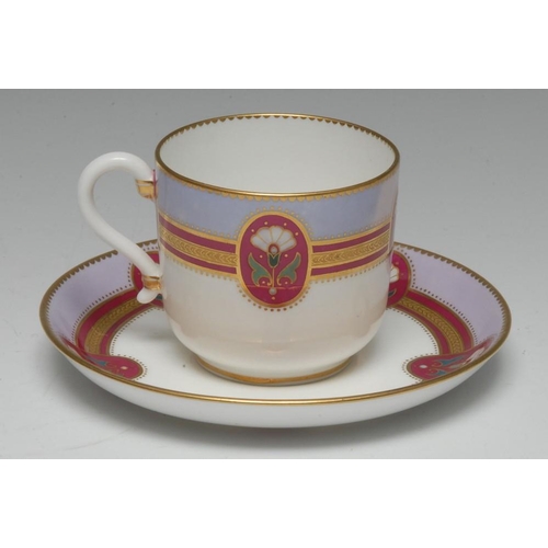 62 - A Minton cup and saucer, influenced by Dr Christopher Dresser, painted with reserves of stiff lilies... 