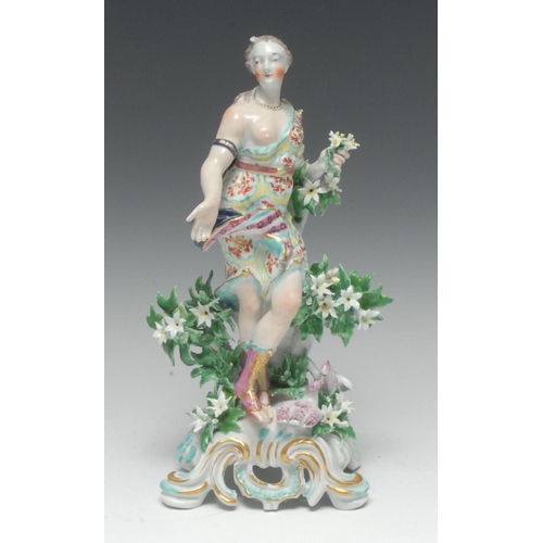 76 - A large Bow figure, of Flora, the goddess stands contrapposto scantily clad and holding a bouquet of... 