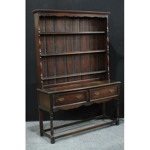 162 - A 19th century oak dresser, moulded outswept cornice above plate racks, the projecting base with two... 