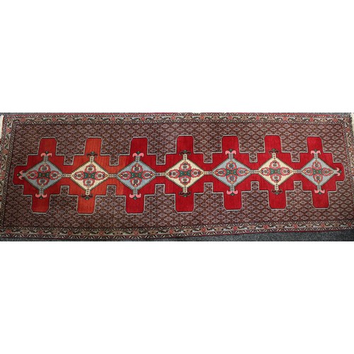 299 - A rectangular Middle Eastern carpet, stylised flowers and geometric motifs, 280cm long, 94cm wide; a... 