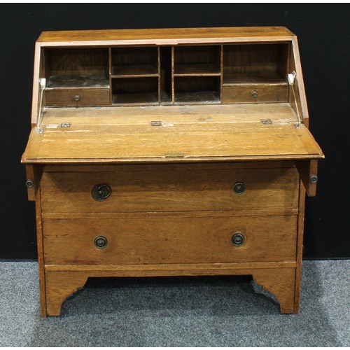 309 - A 20th century oak bureau, fall front enclosing an arrangement of pigeon holes and two small drawers... 