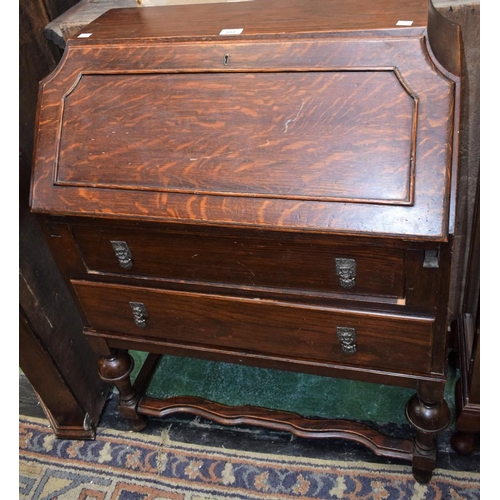 551 - An early-mid 20th century oak bureau, fall front enclosing a fitted interior above two long drawers,... 