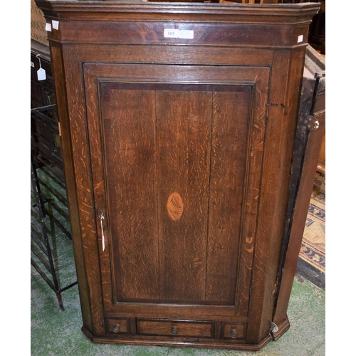 565 - A George III oak and mahogany splay fronted wall hanging corner cupboard, stepped cornice above a re... 