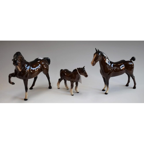 81 - A Beswick prancing brown horse; a similar Beswick horse and foal, brown gloss finish (3)