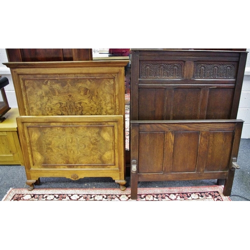 319 - A carved oak single bed head and footboard; a quarter veneered walnut single bed head and footboard.... 