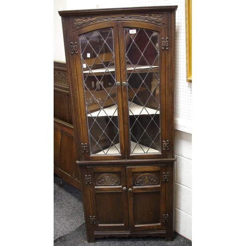 322 - An Old Charm floor standing oak corner cabinet, 2 lead glazed doors over two panelled door cupboards