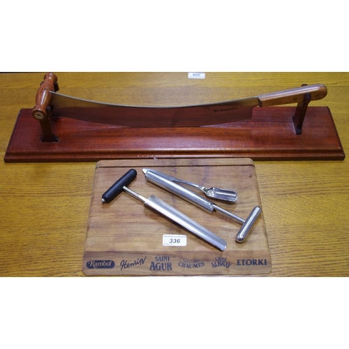 336 - A Dutch Old Amsterdam rocker cheese knife and stand; an advertising cheese board (2)