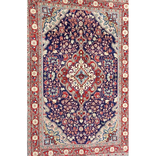 1692 - A hand woven Kashan rug, floral designs in red, navy blue and pink on a beige ground. 160cm x108cm