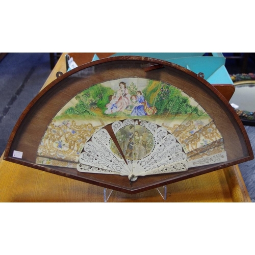 12 - A 19th century lady's bone and silk fourteen-stick fan, painted with a family idyll in a flowering m... 