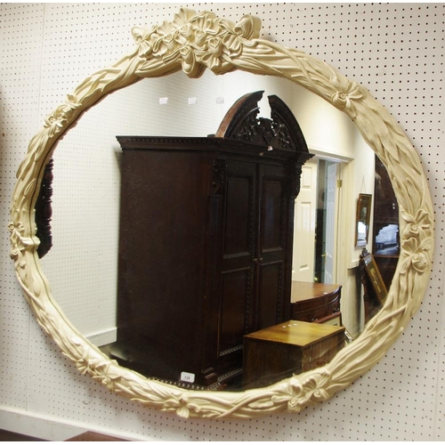 126 - A large contemporary oval wall mirror, mounted throughout with flowers