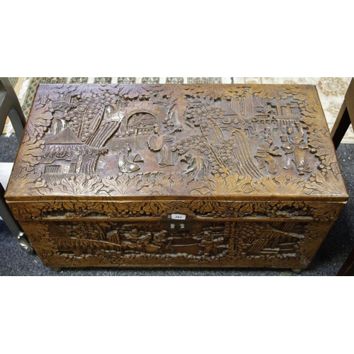 283 - An oriental camphor wood chest profusely carved with oriental scenes throughout.