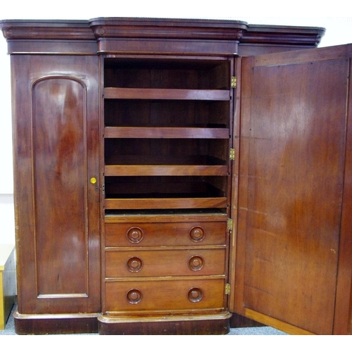 286 - A Victorian mahogany triple compactum wardrobe, ogee cornice, large central mirrored door enclosing ... 