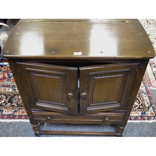 292 - A dark oak side cupboard, oversailing top, two fielded panel doors over long drawer, turned legs. 87... 