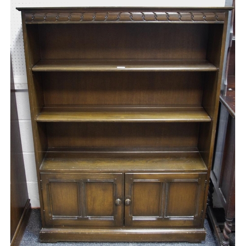 296 - An oak floor standing bookcase, adjustable shelves over two panel door cupboard, plinth base. 137.5c... 