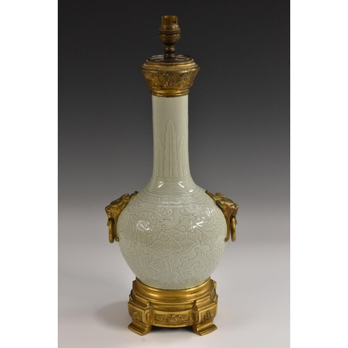 424 - A Chinese celadon and ormolu mounted bottle vase table lamp, in relief with lotus and scrolls, the n... 