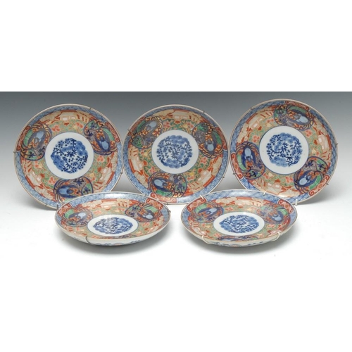 481 - A set of five Chinese Imari circular plates, each decorated with blue pine mons, within three stylis... 