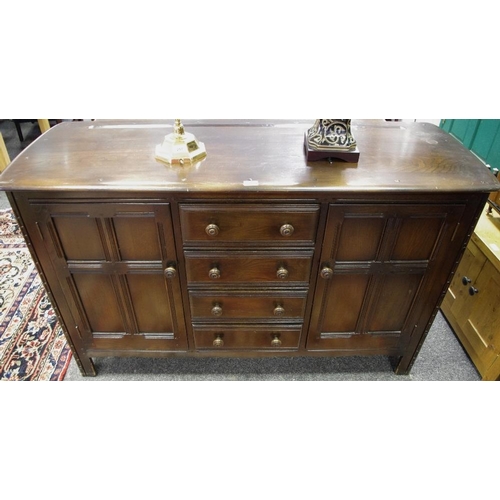 372 - An Ercol dark oak sideboard, oversailing top, four drawers flanked by cupboards, stile feet. 90cm hi... 