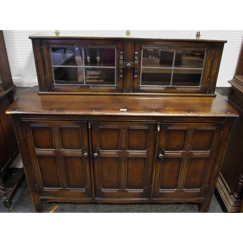 373 - An oak sideboard oversailing top, three panelled door cupboard to base, stile feet; a conforming wal... 