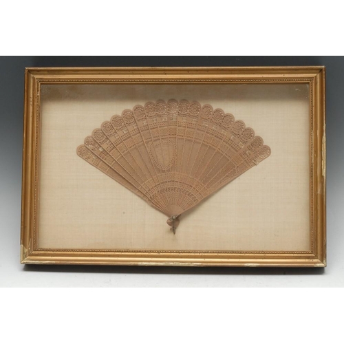 501 - A Chinese boxwood nineteen-stick brise fan, pierced and carved with a shield shaped cartouche monogr... 