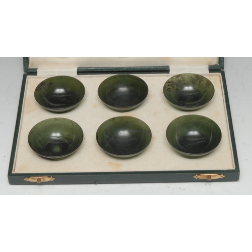 508 - A set of six Chinese spinach jade circular bowls, 6cm diam, retailed by H Simmons, Burlington Arcade... 