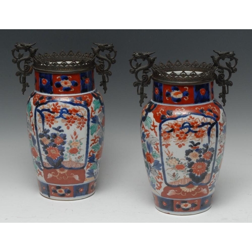 510 - A pair of Japanese Imari patinated bronze-mounted porcelain baluster vases, painted in the typical p... 