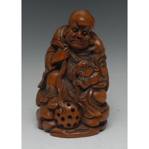 514 - A Chinese bamboo figure, carved as an elder with cloth ball and temple lion, 19cm high