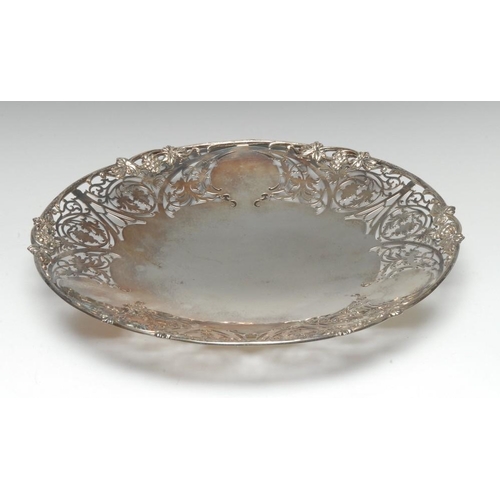 571 - A 20th century silver shaped circular table centre dish, with deep pierced border of scrolling folia... 