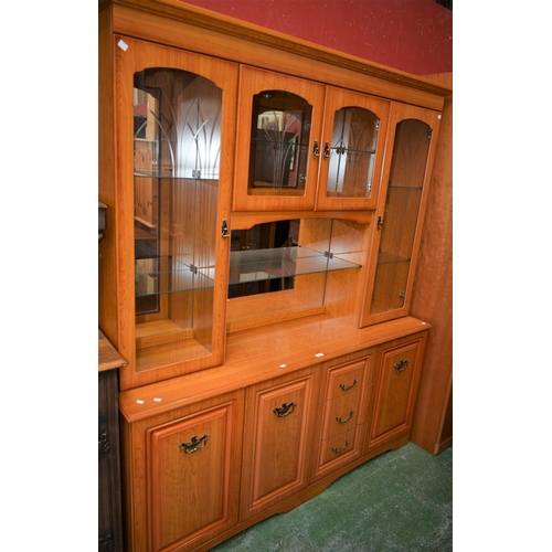 552 - A contemporary bookcase/side cabinet, outswept cornice above an arrangement of glazed doors, the bas... 