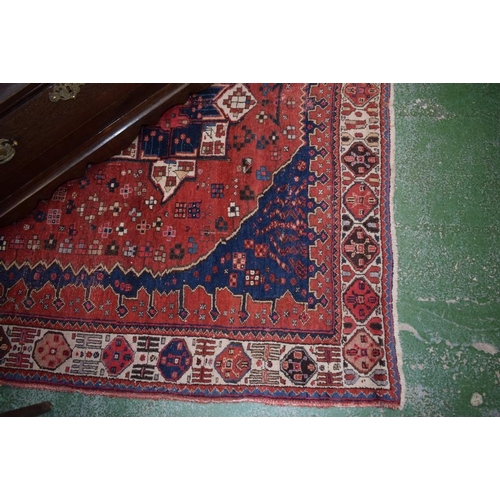 535 - A Middle Eastern style carpet, decorated throughout with geometric motifs on a predominantly crimson... 