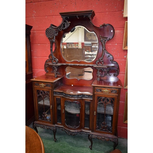 572 - A late 19th/early 20th century mahogany salon display cabinet, the shaped superstructure centred by ... 