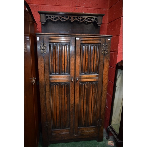 580 - An early 20th century oak housekeeper's cupboard/hall robe, moulded rectangular top crested by a pie... 